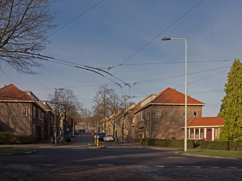 Middenweg in de Geitenkamp met bakstenen woningen en trolleybusdraden