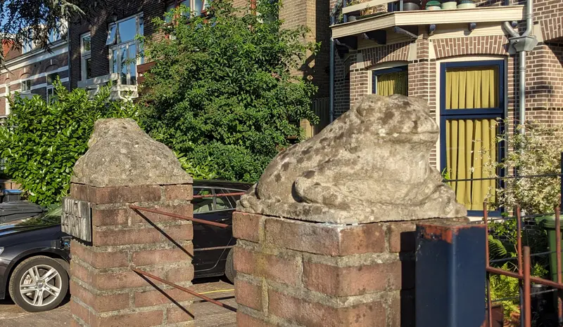 Twee stenen padden op bakstenen pilaren bij een woning aan Onderlangs