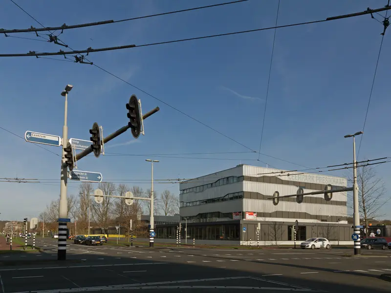 Kruispunt van de Laan van Presikhaaf en de IJssellaan met verkeerslichten en een kantoorgebouw