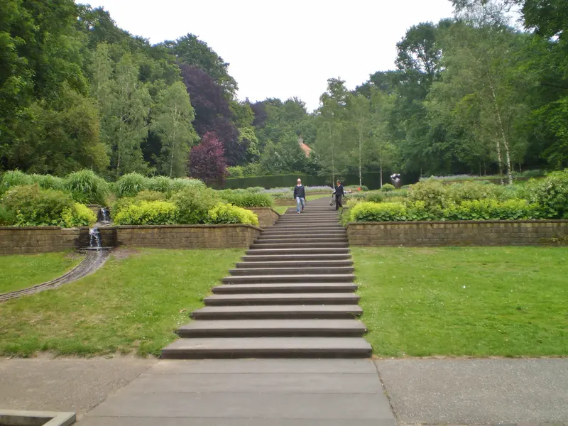 Brede trap tussen gazons en hoge bomen in park Sonsbeek