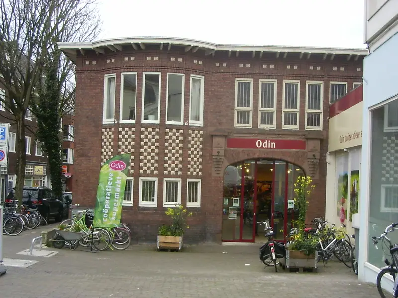 Karakteristiek bakstenen hoekpand met winkel aan de Spijkerlaan in het Spijkerkwartier